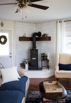 a living room filled with furniture and a fire place in the middle of it's wall