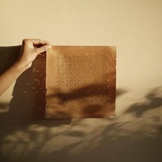 a person holding up a piece of brown paper