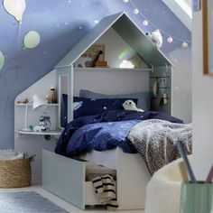 a child's bedroom decorated in blue and white with hot air balloons on the ceiling