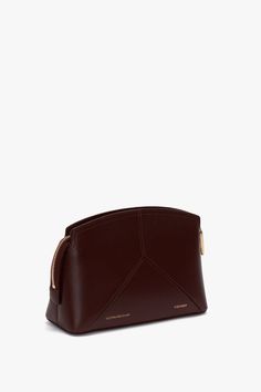 New to the house’s leather goods edit and a favourite of Victoria’s, the Victoria Crossbody in rich Burgundy marries masculine and feminine references. Crafted from a textured, semi-shine, calf leather, it has a structured design with elegant curved top and leather panels stitched to form the house’s signature V shape. An adjustable and removable strap, engraved zip puller with padlock closure, internal flat pocket and textile lining make this a practical and polished option for the new season. Elegant Textured Leather Rectangular Pouch, Elegant Textured Leather Pouch, Elegant Smooth Grain Pouch For Everyday Use, Modern Textured Leather Pouch For Formal Occasions, Modern Formal Textured Leather Pouch, Elegant Leather Pouch With Removable Pouch, Modern Textured Leather Burgundy Bags, Elegant Formal Soft Leather Pouch, Modern Burgundy Textured Leather Bag