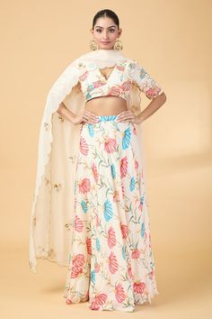 Off white yoke blouse with floral print and aari, zardosi embroidery. Paired with coordinating lehenga and scallop hem dupatta. - Aza Fashions Festive V-neck Set With Floral Print, Festive Floral Print V-neck Set, Anarkali Sets With Floral Print And V-neck, White Lehenga With Printed Motifs For Festive Occasions, Festive White Lehenga With Printed Motifs, White Lehenga With Printed Motifs, Bollywood Style White Blouse With Floral Print, White Bollywood Blouse With Floral Print, White Bollywood Sets With Printed Motifs