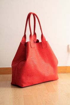 "Oversized tote bag handmade with an amazing red embossed croc effect leather. This high-quality calf leather is strong and soft at the same time. For a good organization of space, has an internal big zippered canvas bag that fits a 15\" laptop. The canvas bag is removable and has an outside pocket. This very special tote also has metallic clasps for changing the shape of the bag and closing the top. It is available in brown, tan, red and black. ♥ Can be the perfect gift for you or your loved on Rectangular Textured Leather Hobo Bag For Travel, Handheld Textured Leather Travel Bag, Red Box Bag With Large Capacity And Double Handle, Red Box Bag With Double Handle And Large Capacity, Red Bag For Daily Use, Red Box Bag With Large Capacity For Daily Use, Red Large Capacity Box Bag For Daily Use, Red Large Capacity Box Bag For Travel, Large Capacity Red Box Bag For Daily Use