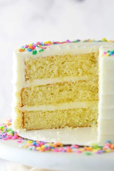 a slice of cake with white frosting and sprinkles