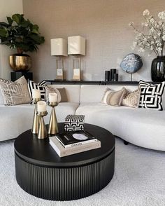 a living room with white couches and black coffee table in it's center