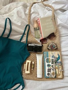 Summer aesthetic beach bag with swimsuit, sunglasses, and other aesthetic beach day items. What To Pack For Beach Day, Bag For Beach Summer, Beach Bag Necessities, Whats In My Beach Bag Summer, Whats In My Bag Beach, Summer Car Bag, Summer Beach Essentials, What's In My Beach Bag, Whats In My Bag Summer