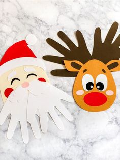 paper reindeer and santa claus masks on a marble surface