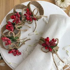 two napkins decorated with red flowers and twine