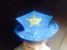 a young boy wearing a blue hat with a star on it