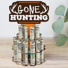 there is a rack with money in it and the words gone hunting above it are stacks of twenty dollar bills