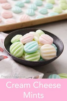 a black bowl filled with cream cheese mints on top of a white and pink table cloth