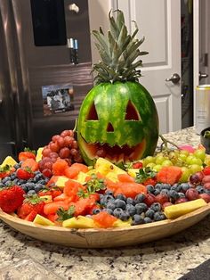 a carved pumpkin sitting on top of a platter of fruit