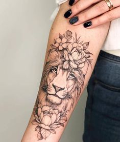 a woman's arm with a lion and flowers on it