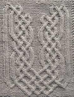 a knitted square with an intricate design on the front and back side, in grey