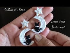 the cat earrings are crocheted and have cats on them, with stars in the background