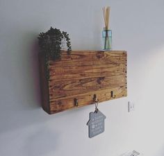 a wooden shelf with some plants on it and a sign hanging from the wall next to it