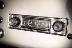 an old fashioned radio sitting on top of a metal stovetop freezer oven with knobs