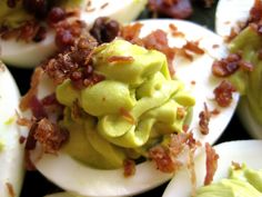 deviled eggs with bacon and avocado on them are ready to be eaten