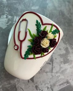 a heart shaped cake decorated with flowers and a stethoscope