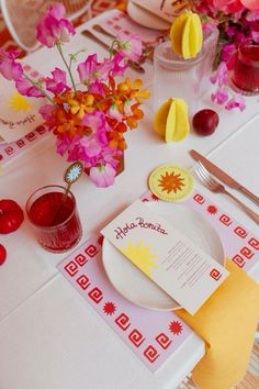 a table set with flowers and place settings for an event or party, including napkins