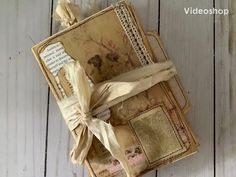 an open book with ribbon tied around it on a white wooden surface, next to a pair of scissors