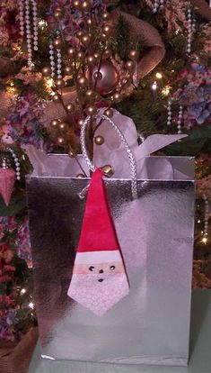 a bag with a santa clause on it sitting in front of a christmas tree