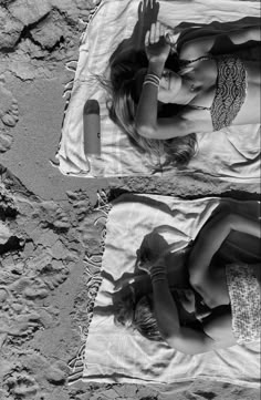 two women laying on towels in the sand