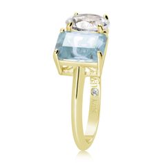 Shimmering in hues of white and blue, this Suzy Levian ring is as on trend as can be, and features a round cut white topaz and an emerald cut blue topaz as a perfectly matched pair. This ring symbolizes a perfect pairing of unique shapes. This ring is constructed from yellow sterling silver, making it durable and easy to clean. The high-shine polish of the piece is sure to draw attention at any cocktail party or special event. Suitable for any occasion, this ring adds dimension to any outfit. Be Formal White Blue Topaz Ring, White Topaz Ring With Blue Topaz Center Stone, White Blue Topaz Ring With Center Stone, Levian Rings, Two Stone Ring, Gemstone Brooch, Cubic Zirconia Bracelet, Unique Shapes, Cubic Zirconia Necklace