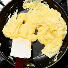 scrambled eggs being cooked in a frying pan