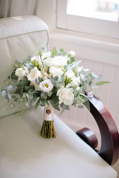 a bouquet of flowers sitting on top of a white chair