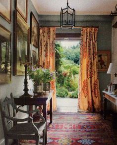 an open door leading to a garden with lots of flowers on the table and chairs