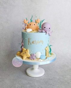 a blue cake decorated with sea animals and under the sea words