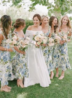 a group of women standing next to each other holding bouquets