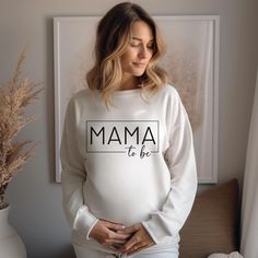 Our "Mama To Be" sweatshirts are comfy and cozy--perfect for fall and winter! Soft and warm, they're a great gift for any mother-to-be, whether for a pregnancy announcement or a baby shower.  Ideal for any situation, a unisex heavy blend crewneck sweatshirt is pure comfort. These garments are made from polyester and cotton. This combination helps designs come out looking fresh and beautiful. The collar is ribbed knit, so it retains its shape even after washing. There are no itchy side seams on these sweaters.  Key features: .: Made with a medium-heavy fabric blend of 50% cotton and 50% polyester (8.0 oz/yd² (271.25 g/m. .: Double-needle stitching at the shoulder, armhole, neck, waistband, and cuff seams add top-tier durability.  .: Pearlized tear-away label.  .: Made using 100% ethically g Pregnancy Reveal Shirt, All About Pregnancy, Mother To Be, Cadeau Baby Shower, About Pregnancy, Pregnancy Reveal, Pregnancy Reveals, Mama Sweatshirt, New Mom Gift