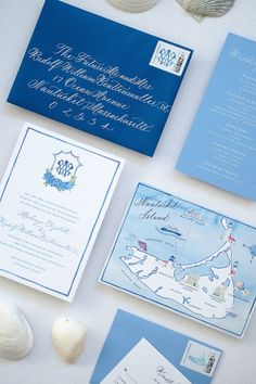 the wedding stationery is laid out on top of the table with shells and seashells