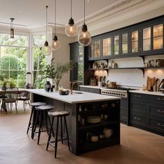 a large kitchen with lots of counter space and lights hanging from the ceiling above it