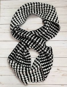 a black and white scarf hanging on a wooden wall