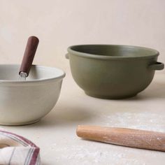 two bowls and a rolling pin on a table