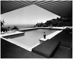 an outdoor swimming pool in the middle of a house with a view of the ocean