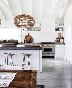 a kitchen with an island and stools next to the counter top in front of it