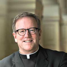 a man wearing glasses and a priest's outfit