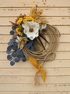 a wreath made out of rope with flowers and leaves