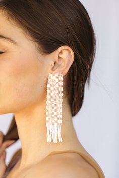 This Mary is all about how her garden grows. Our hand beaded checker print statement earrings with fringe detail on the bottom are perfect to be paired with our Evan hat, or a basic white t-shirt. available in peach plaid: our opaque peach with bright white - glass bead plaid statement earrings - made in Mexico - stainless steel post back - 4” length 1” width .75” tassels White Beaded Earrings For Spring, Trendy Fringe Earrings For Summer, Trendy Spring Jewelry With Fringe, White Fringe Earrings For Summer, Chic Summer Fringe Jewelry, Neutral Seed Bead Earrings, Plaid Seed Bead Earrings, Honeycomb Beaded Earrings, Checkered Beaded Earrings