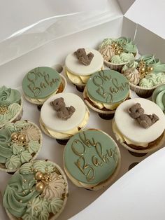 a box filled with lots of cupcakes covered in frosting and decorated with teddy bears