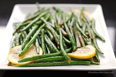 a white plate topped with green beans and orange slices