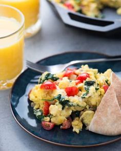 an omelet on a plate next to a glass of orange juice