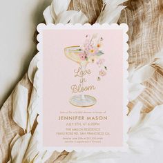 a pink and gold bridal party card with flowers in a champagne glass on it