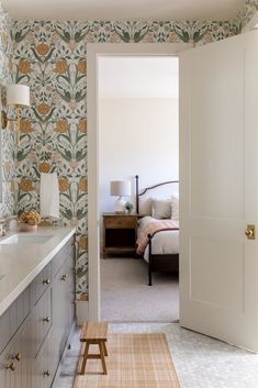 an open door leading to a bedroom with a bed in the background and a dresser next to it