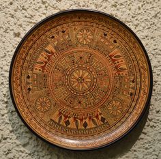 a brown and black plate sitting on top of a wall