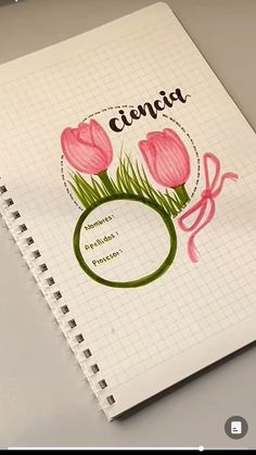 a spiral notebook with some pink flowers on it