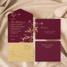 the wedding stationery is set on top of a satin sheet and has gold foil flowers